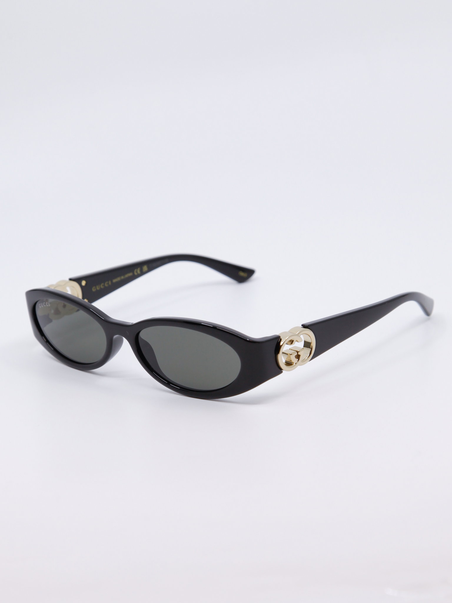 Smal, svart solbrille med vintage-design og gull-logo på brillestengene