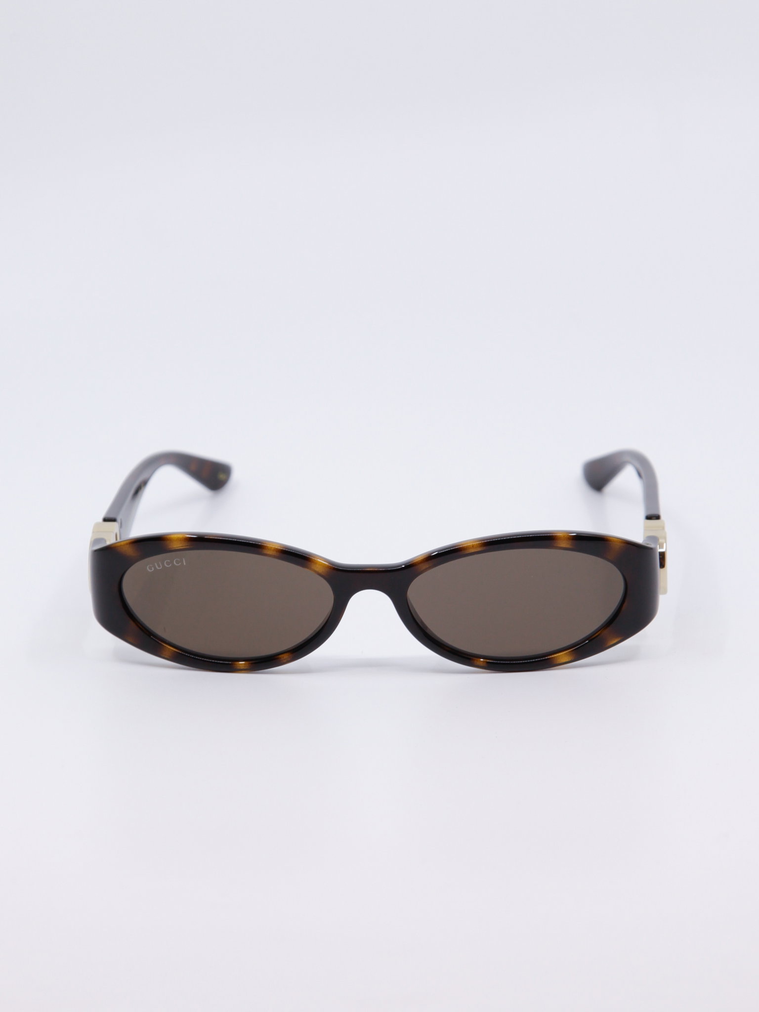 Smal, brun solbrille med vintage-design og gull-logo på brillestengene