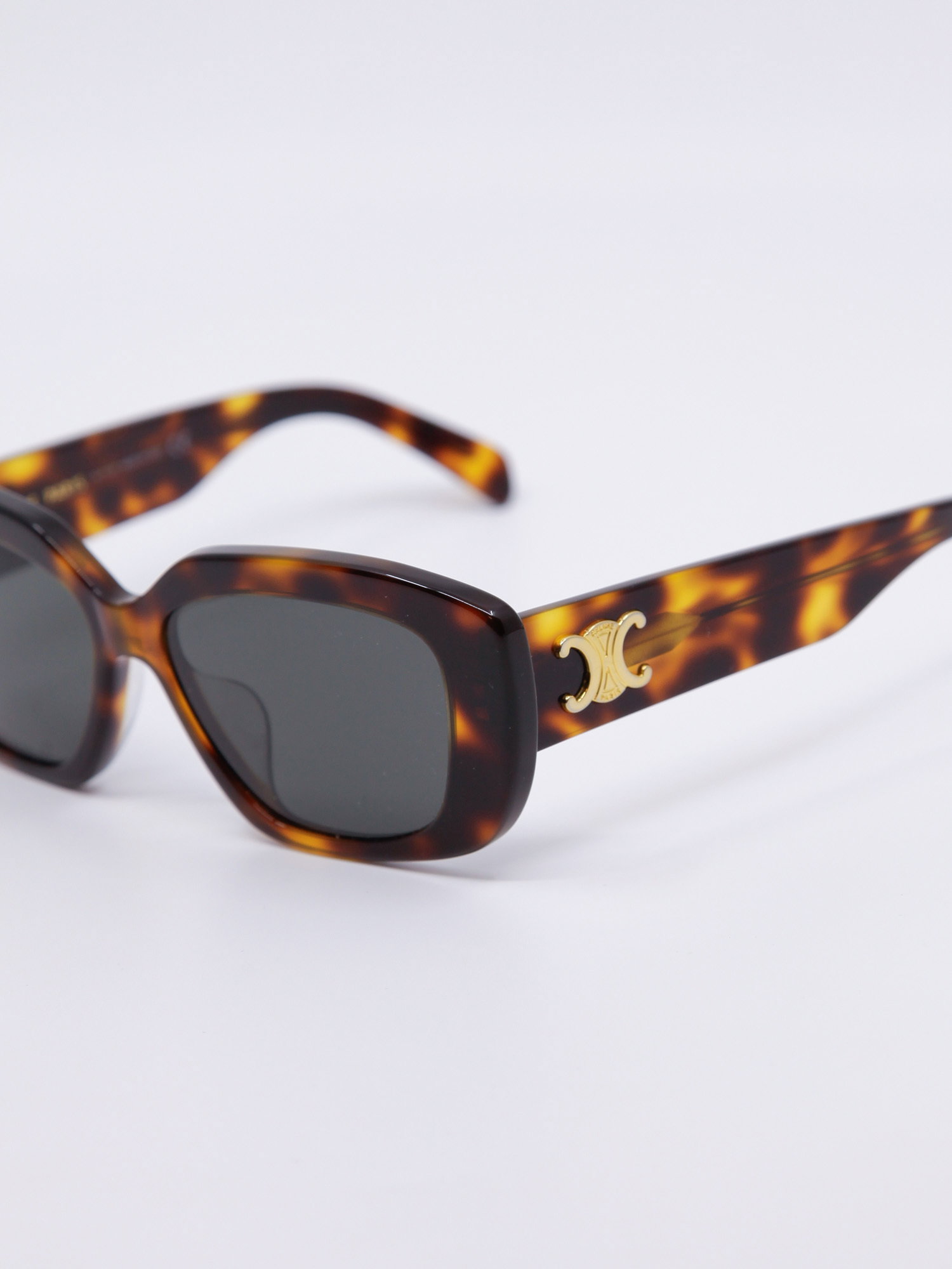 Mørkebrun solbrille med avrundet svak cateye fasong