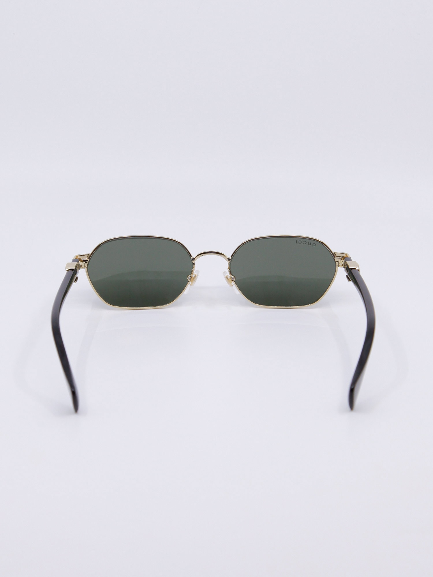 Smal metallsolbrille med gullramme og svarte brillestenger