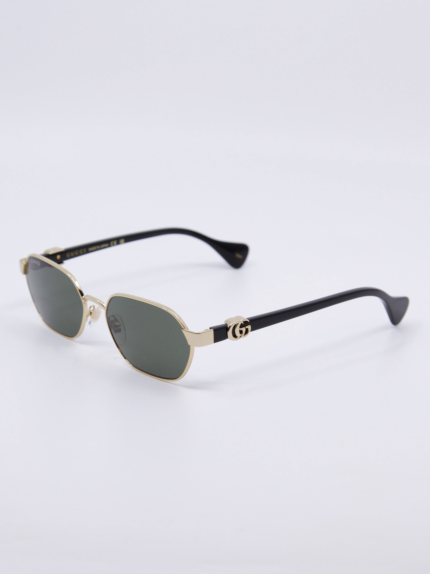 Smal metallsolbrille med gullramme og svarte brillestenger