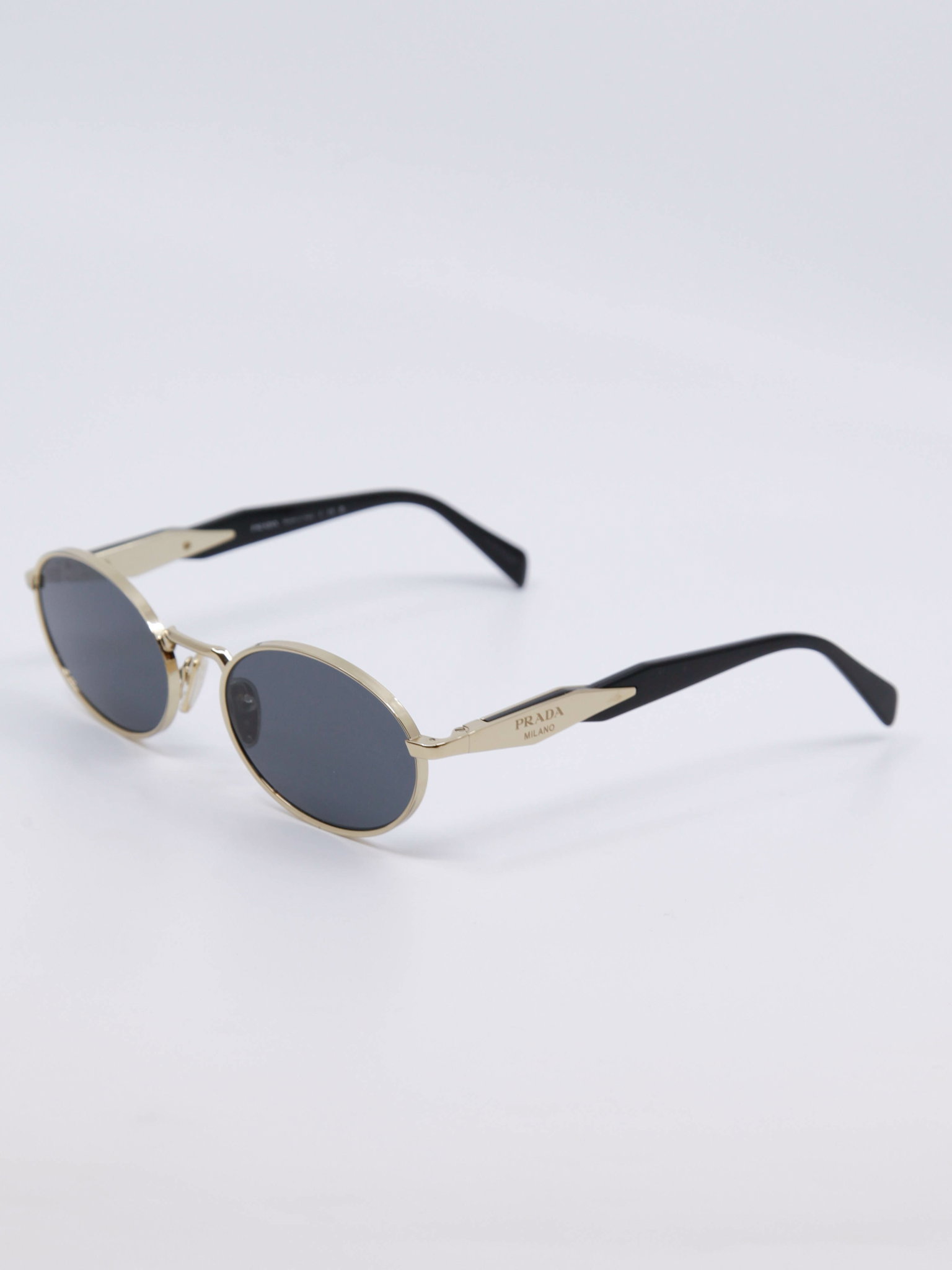 Oval metallsolbrille i gull med blå solbrilleglass