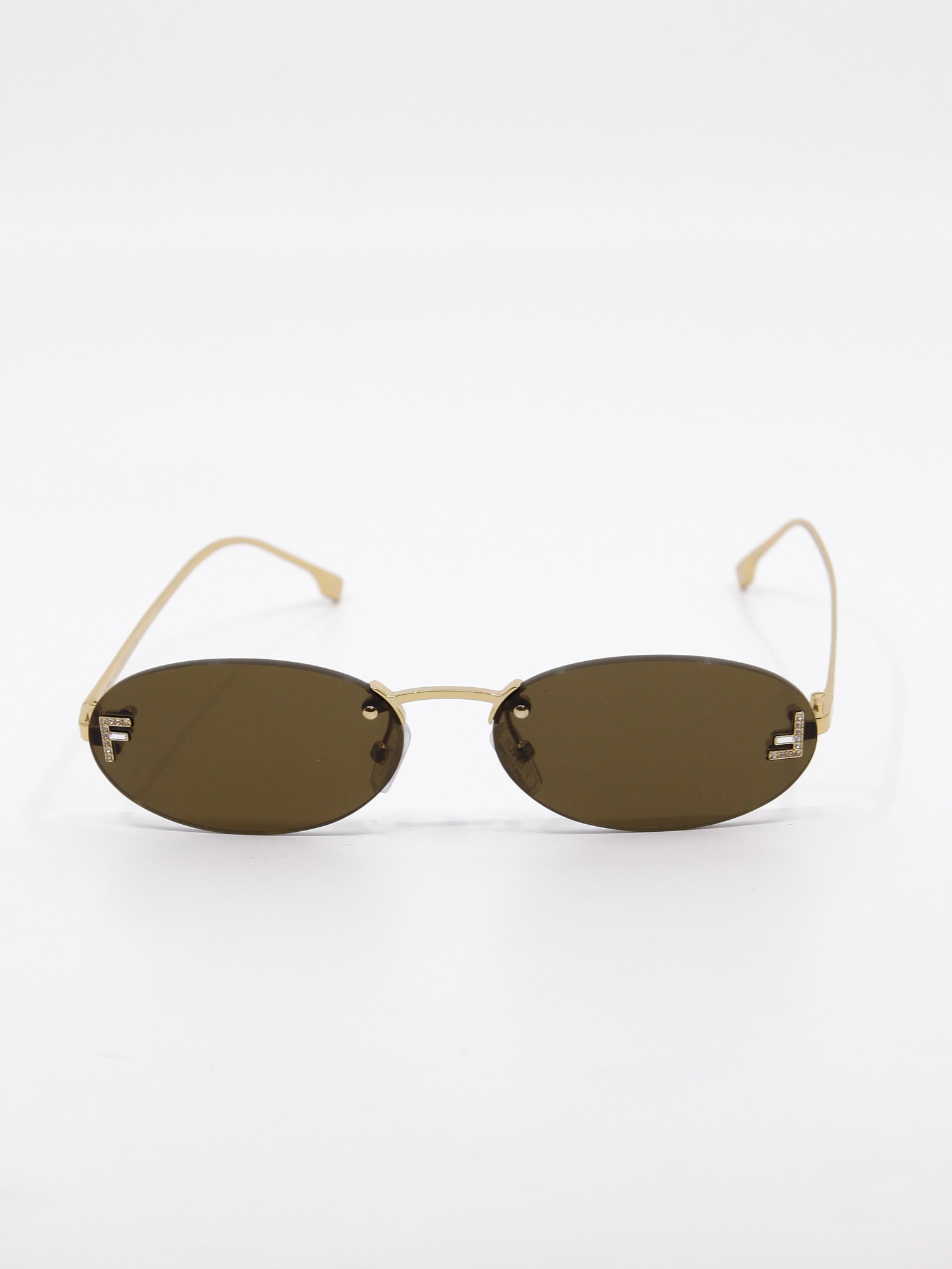 Oval metallsolbrille i gull med  glitrende logo-detalj på glasset