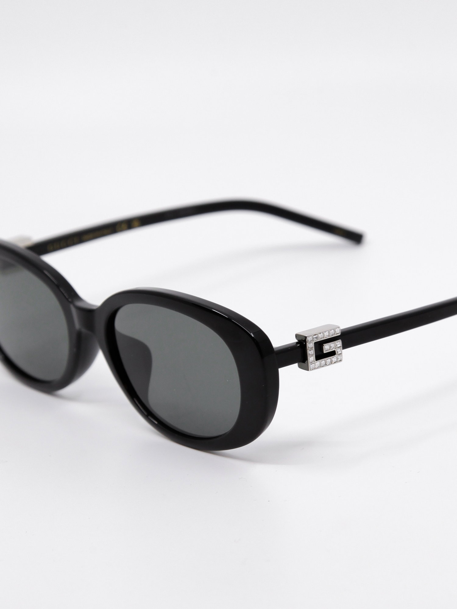 Svart oval solbrille med grå solbrilleglass