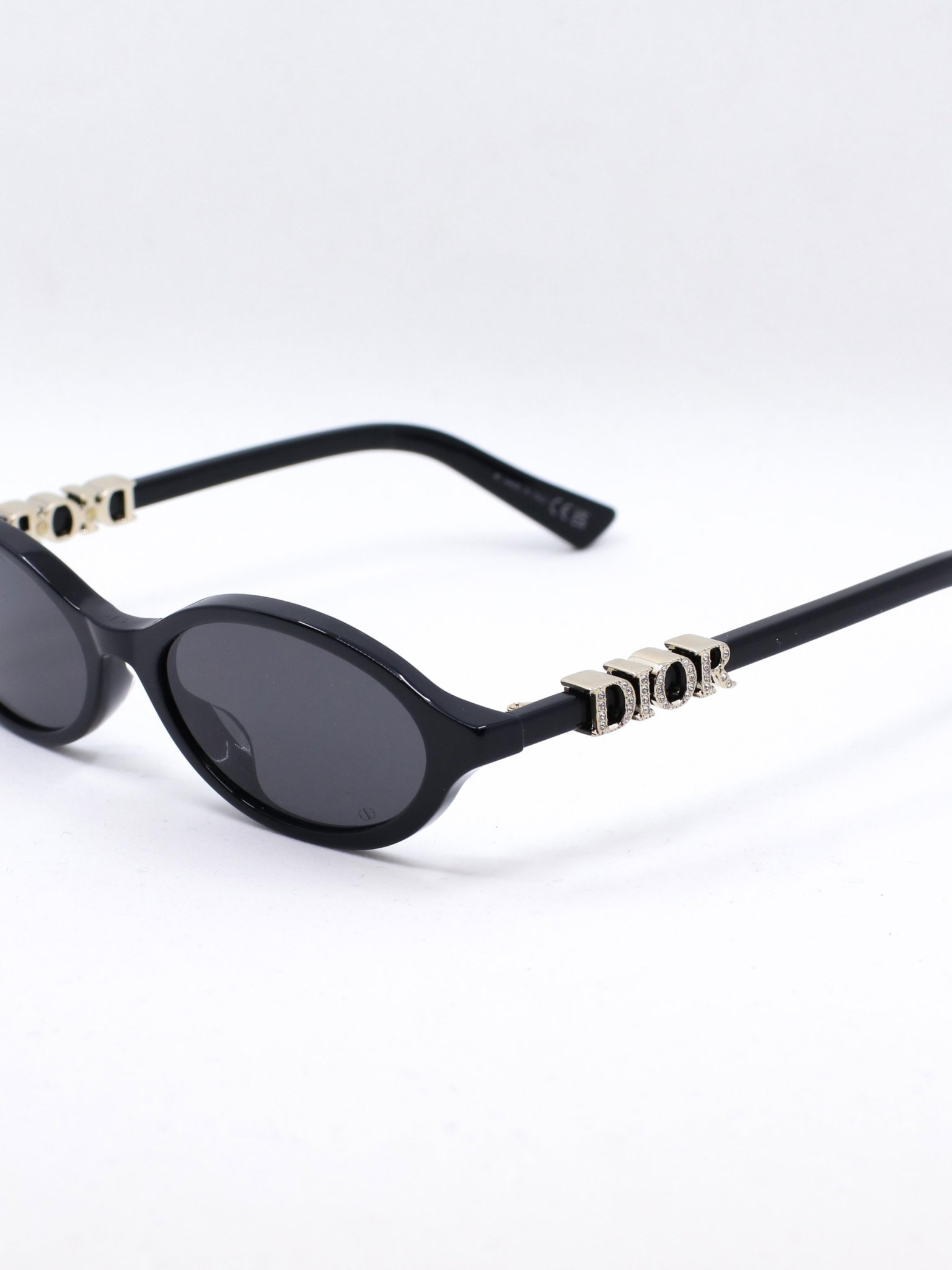 Svart oval solbrille med mørke glass