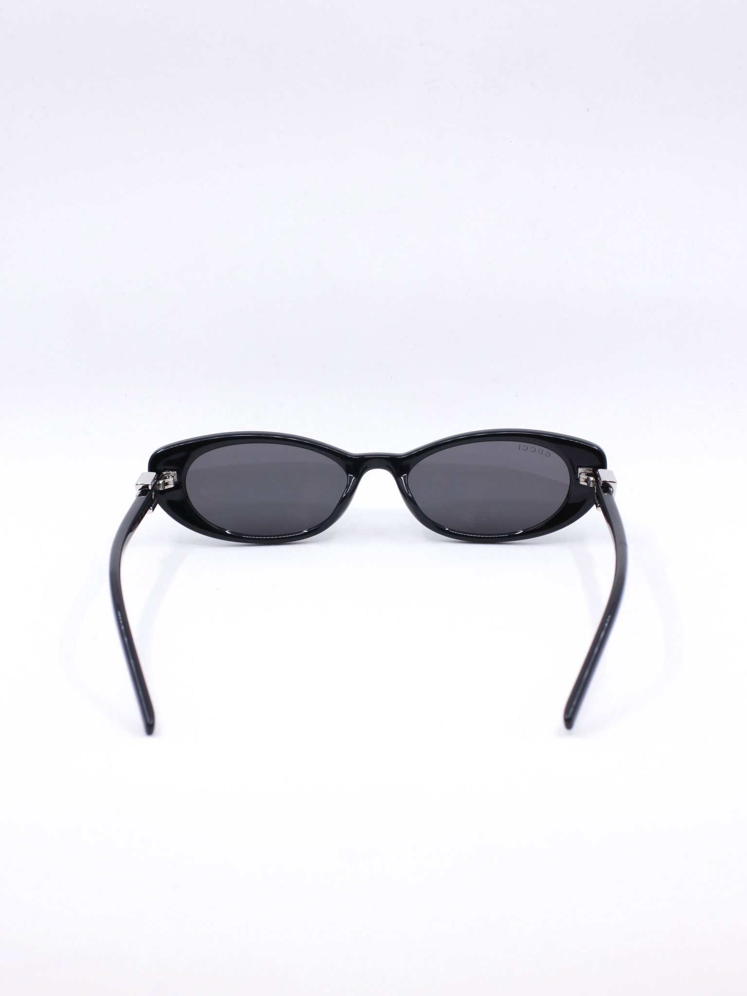 Smal solbrille med avrundet cateye fasong i fargen svart