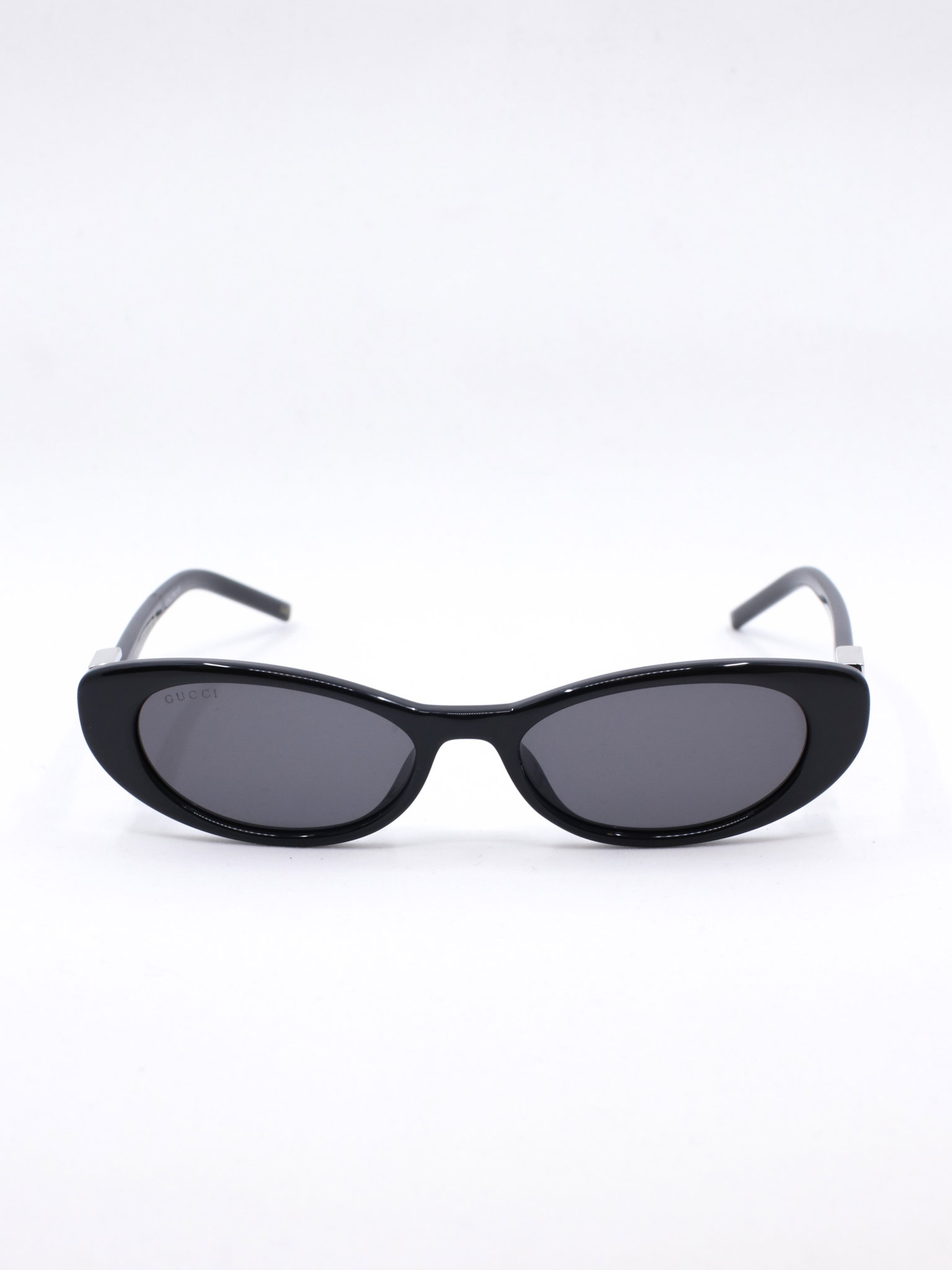 Smal solbrille med avrundet cateye fasong i fargen svart