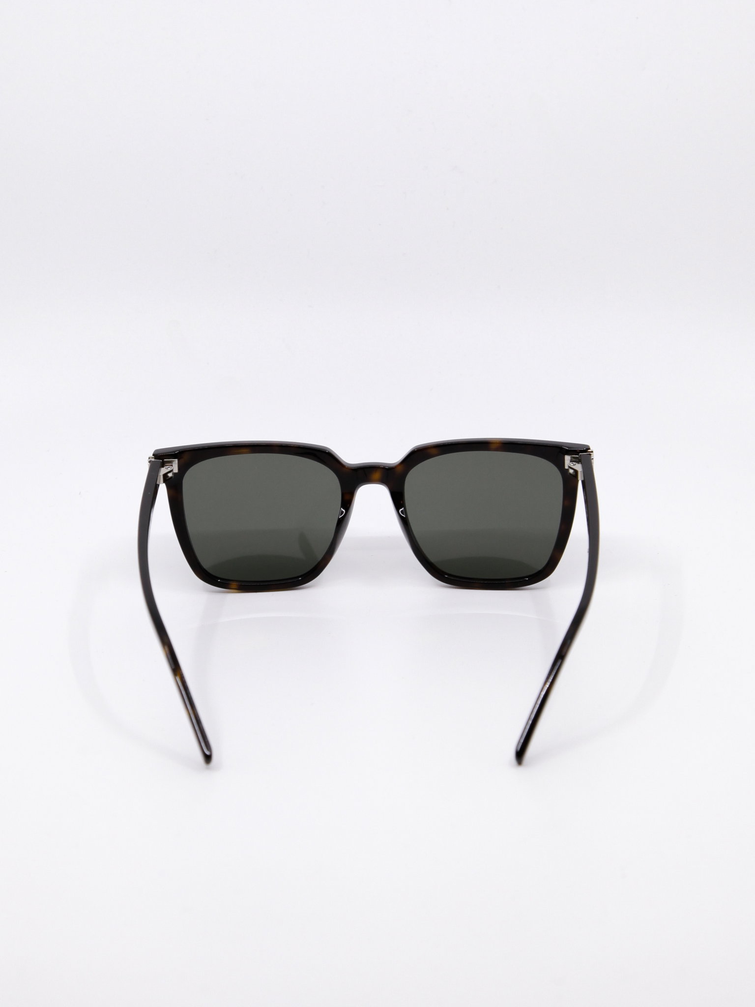 Solbrille med store solbrilleglass, brun ramme og mørke solbrilleglass. Rektangulær fasong