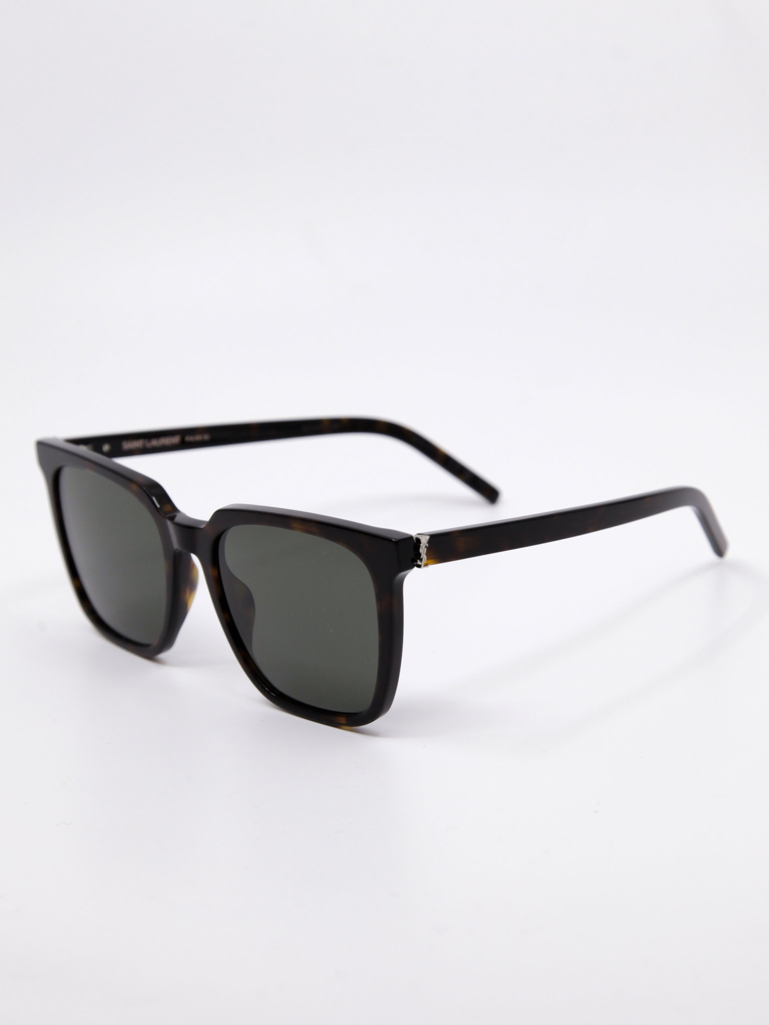 Solbrille med store solbrilleglass, brun ramme og mørke solbrilleglass. Rektangulær fasong