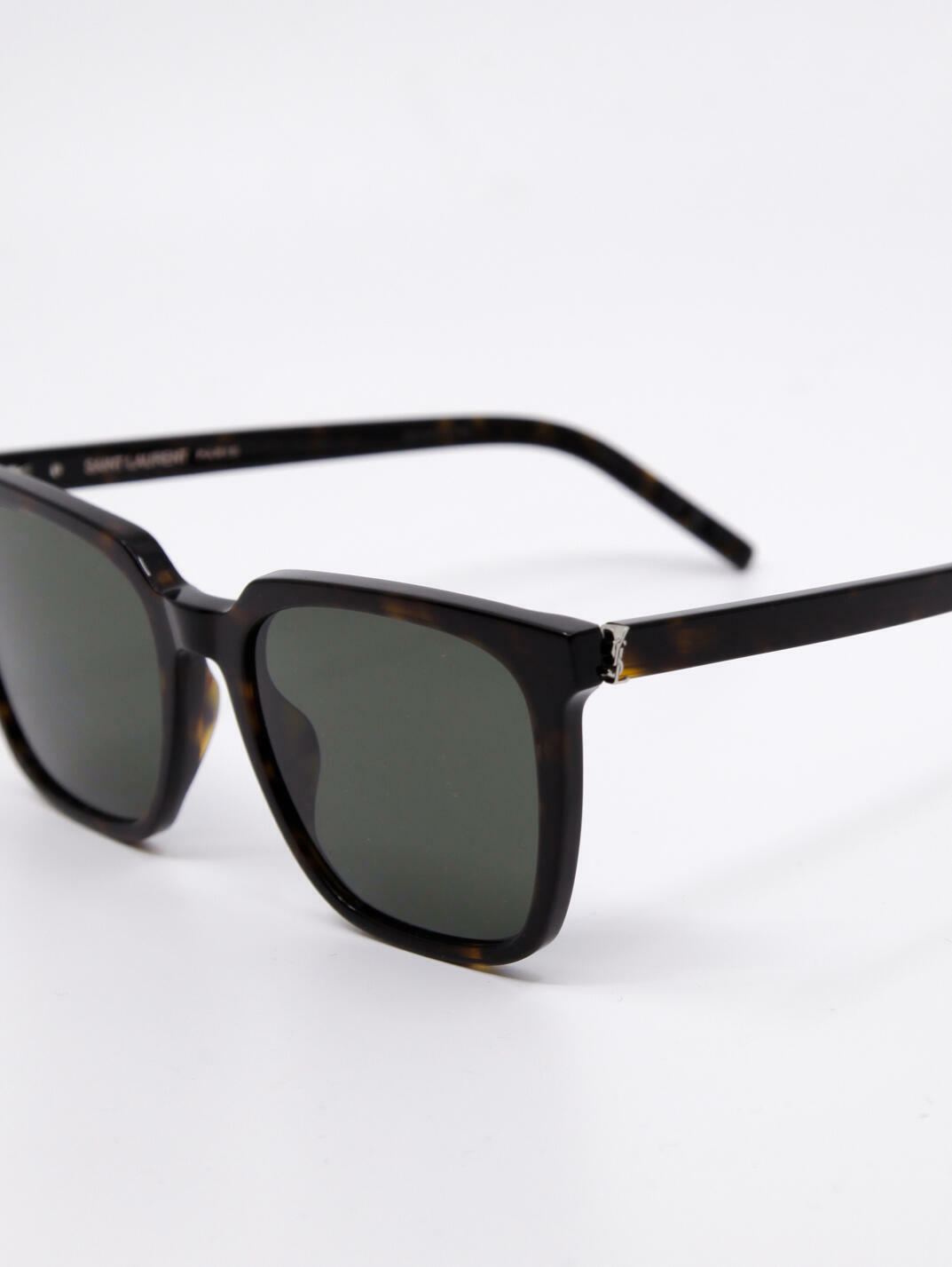 Solbrille med store solbrilleglass, brun ramme og mørke solbrilleglass. Rektangulær fasong