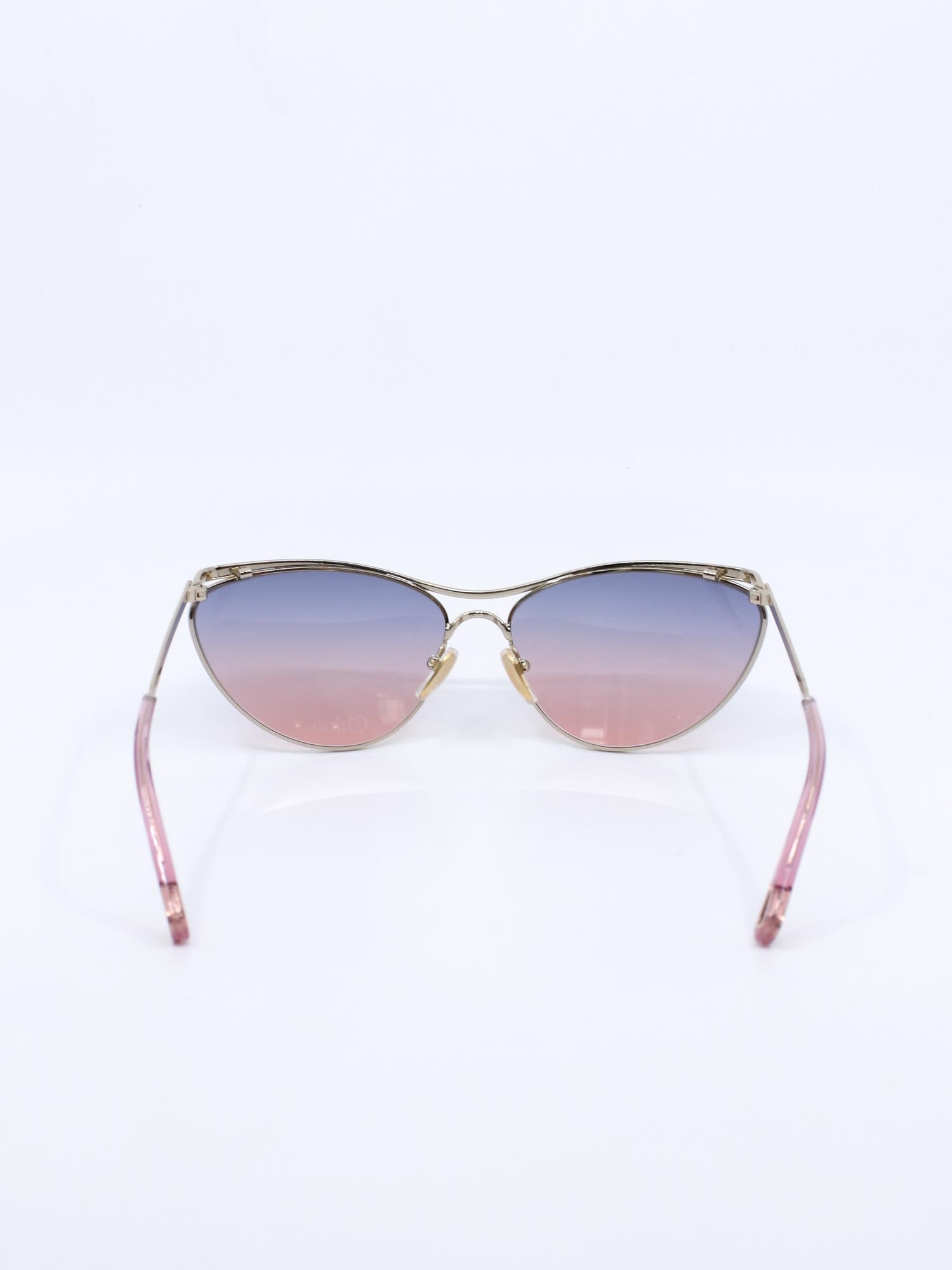 Metallsolbrille i gull med cateye fasong og rosa graderte glass