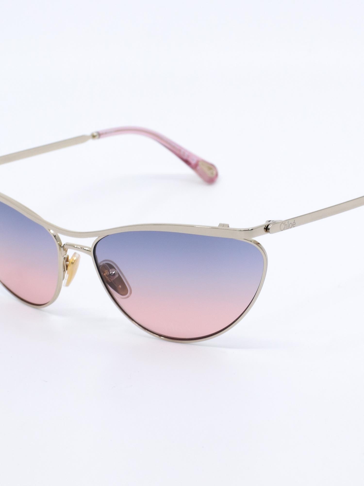 Metallsolbrille i gull med cateye fasong og rosa graderte glass