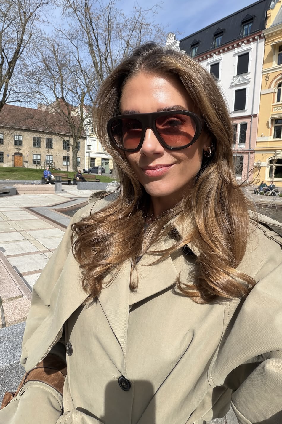 Dame med brunt hår og oversized pilot solbriller med rødbrune glass
