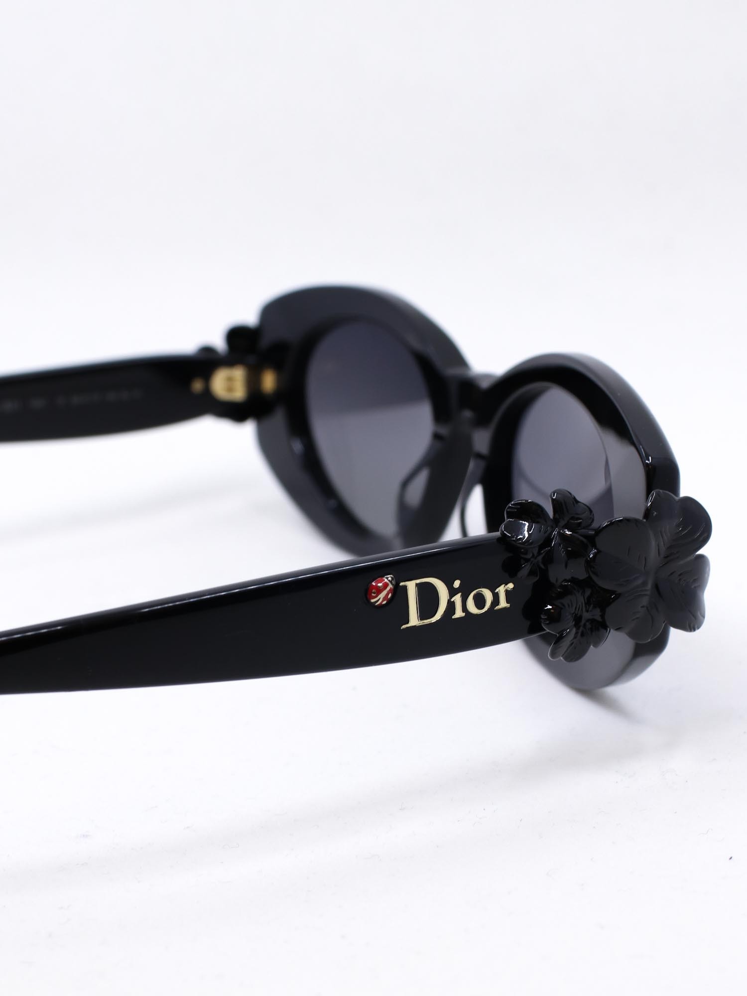 Solbrille med unikt design med trebladet kløver og en liten marihøne