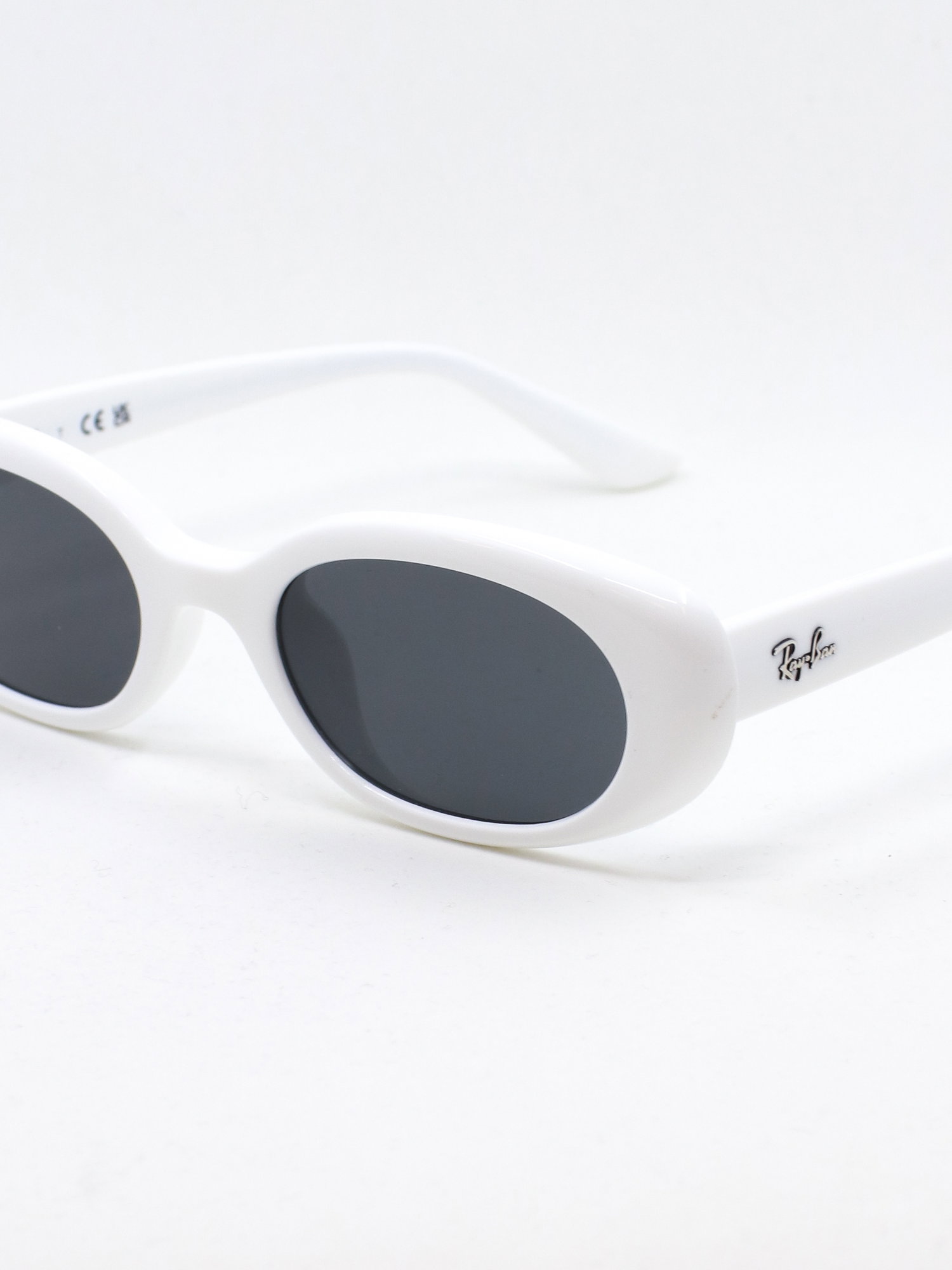 Hvit solbrille med oval fasong med grå solbrilleglass