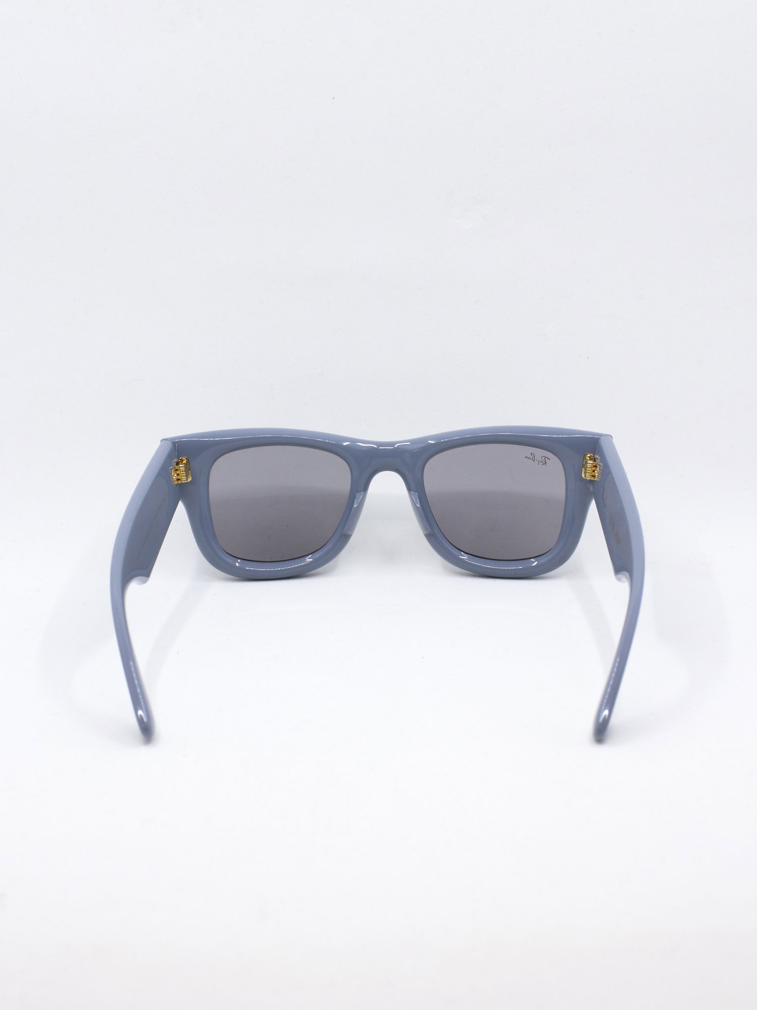 Solbrille med blå, klumpete ramme og lyse solbrilleglass