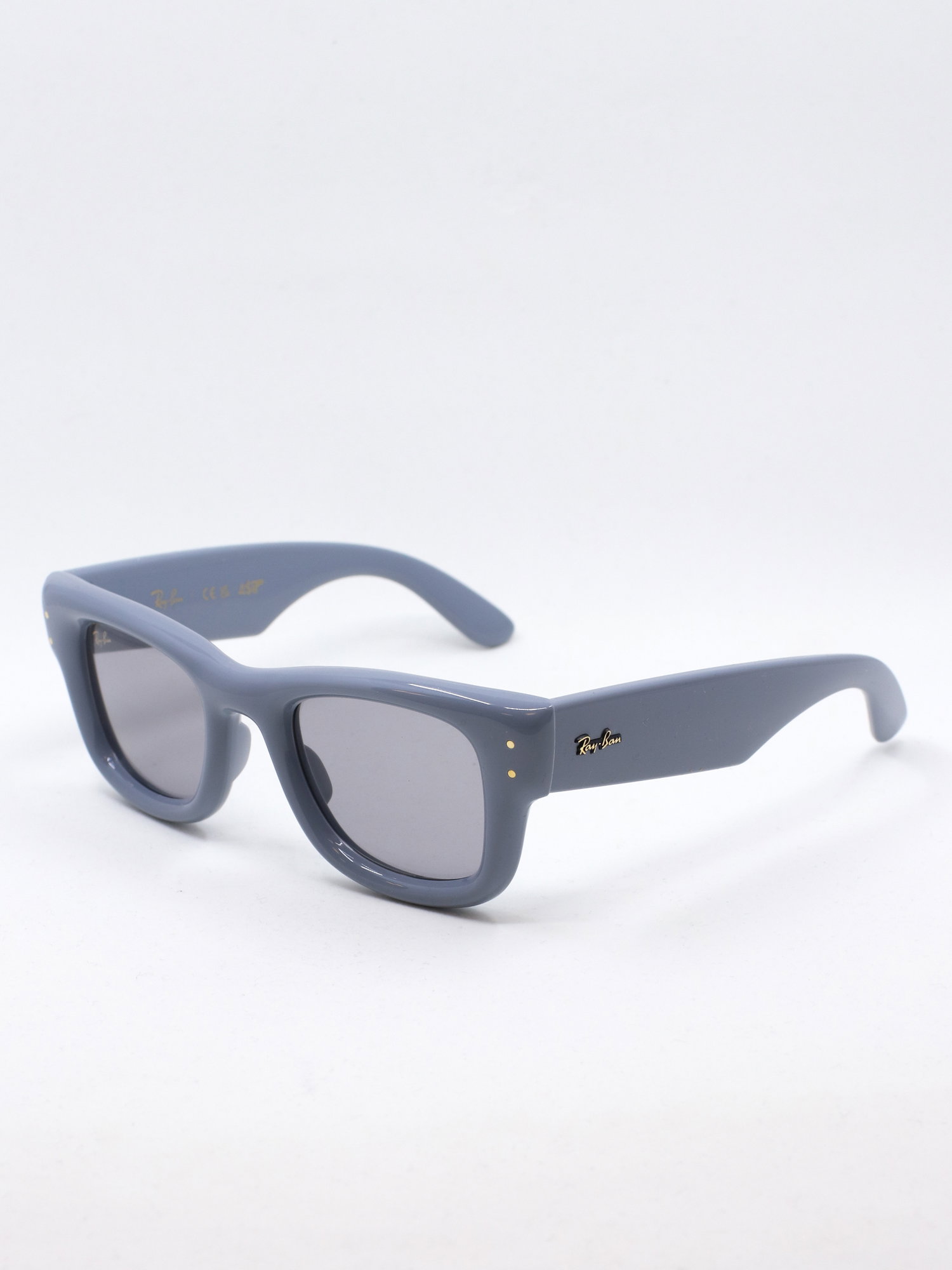 Solbrille med blå, klumpete ramme og lyse solbrilleglass