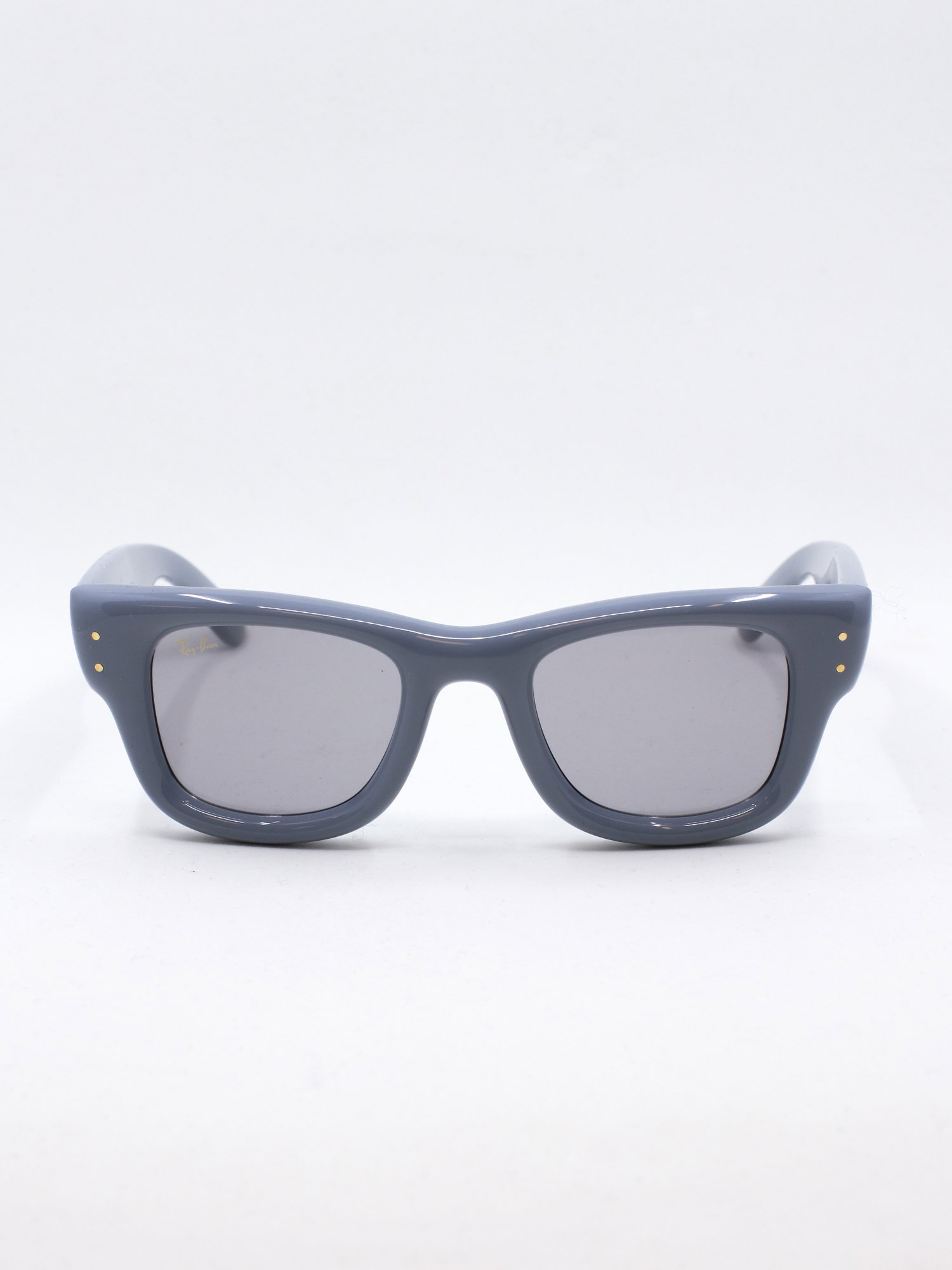 Solbrille med blå, klumpete ramme og lyse solbrilleglass