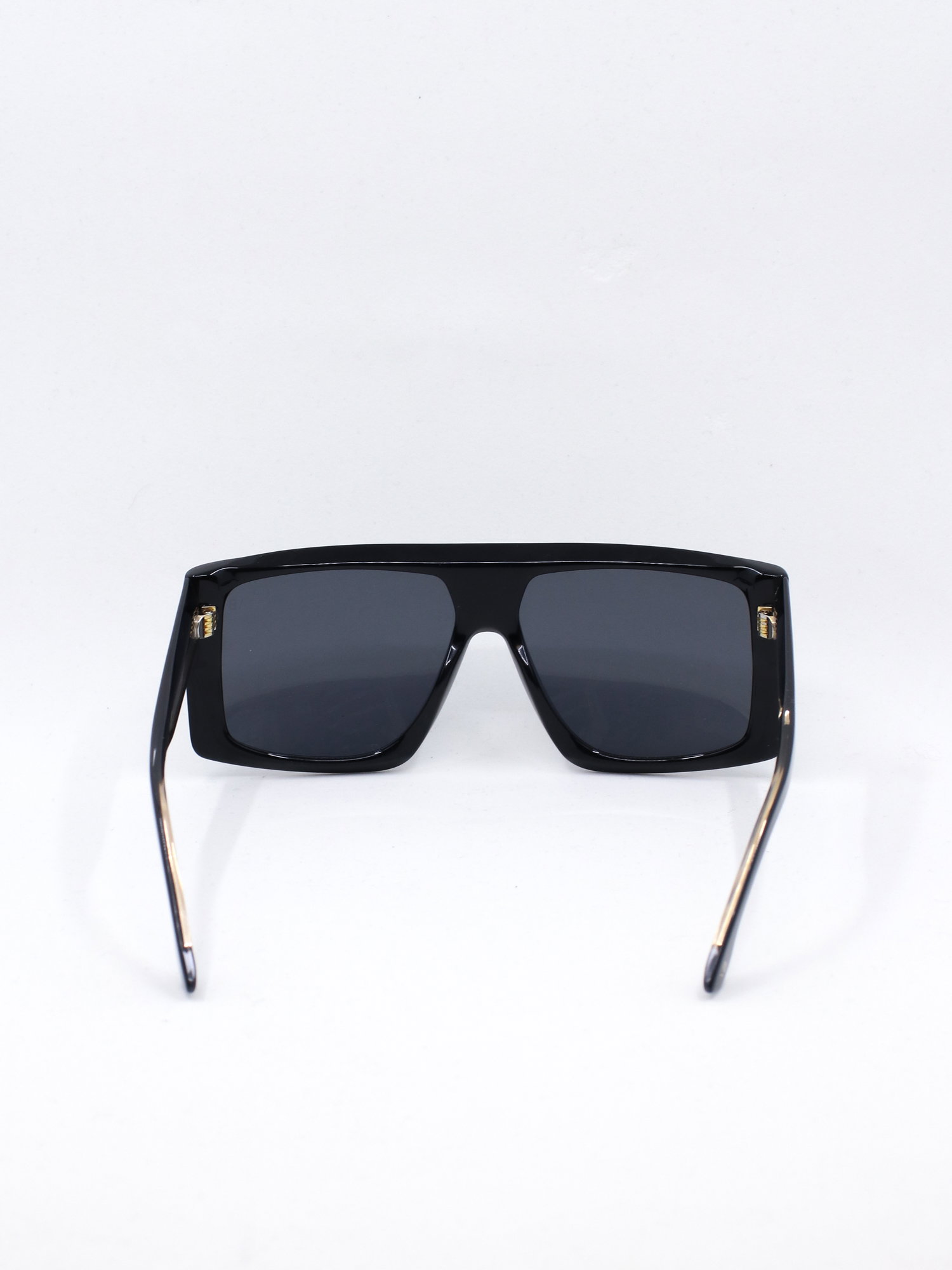 Oversized solbrille i svart med små gulldetaljer ved brillestengene