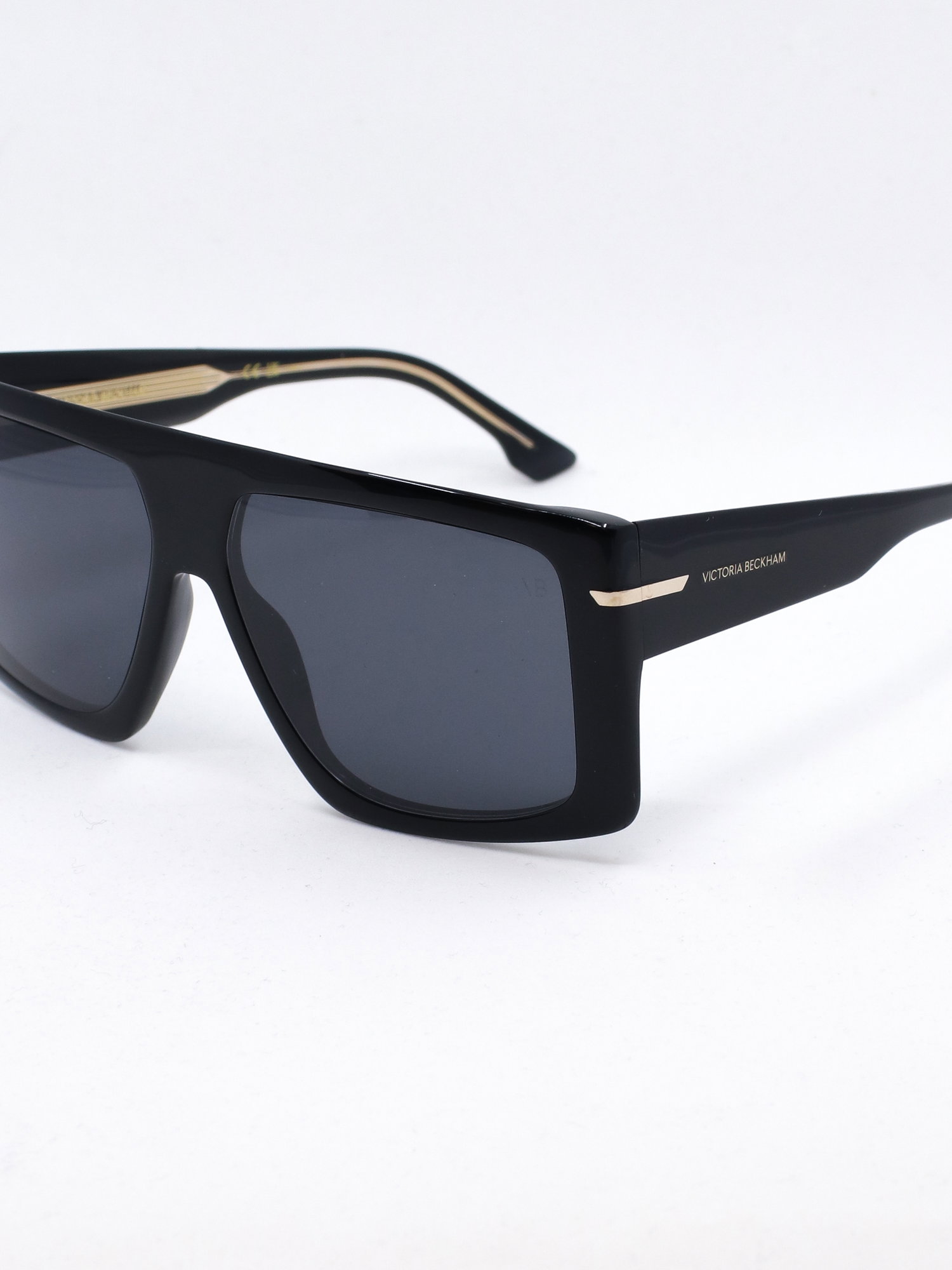Oversized solbrille i svart med små gulldetaljer ved brillestengene