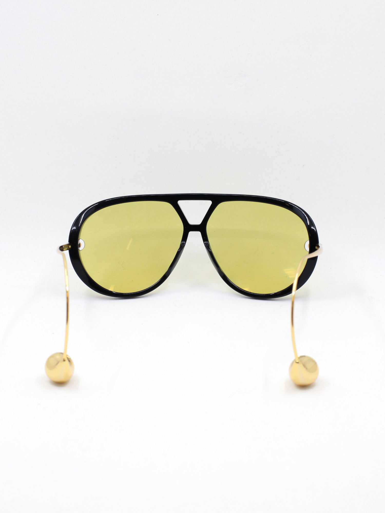 Pilotsolbrille i svart med gule glass og brillestenger med perleformede tupper