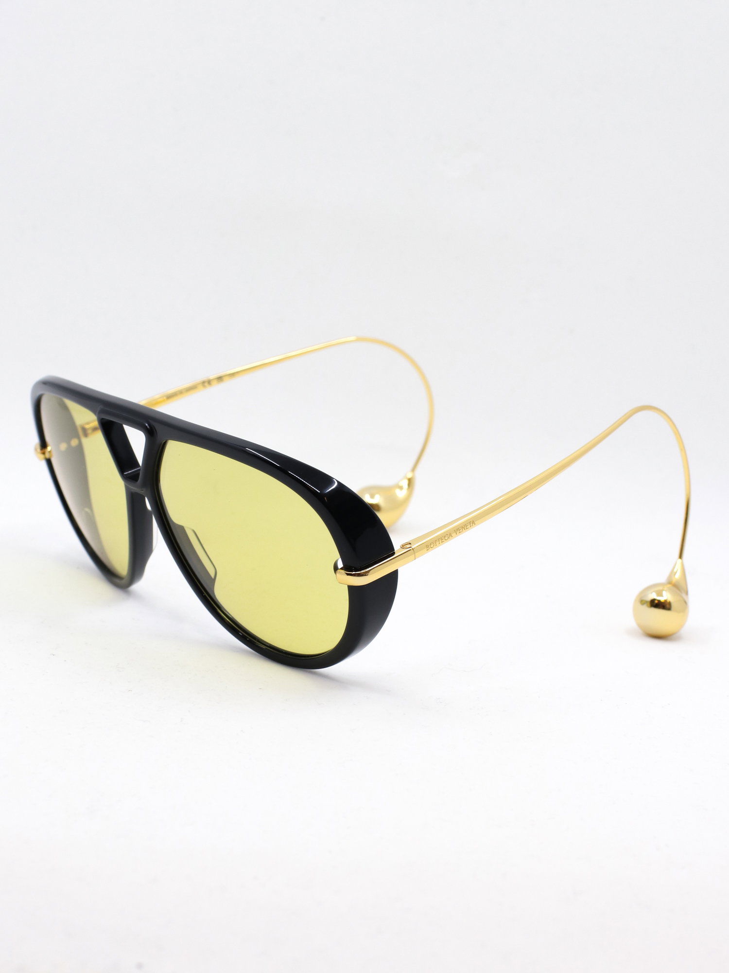 Pilotsolbrille i svart med gule glass og brillestenger med perleformede tupper