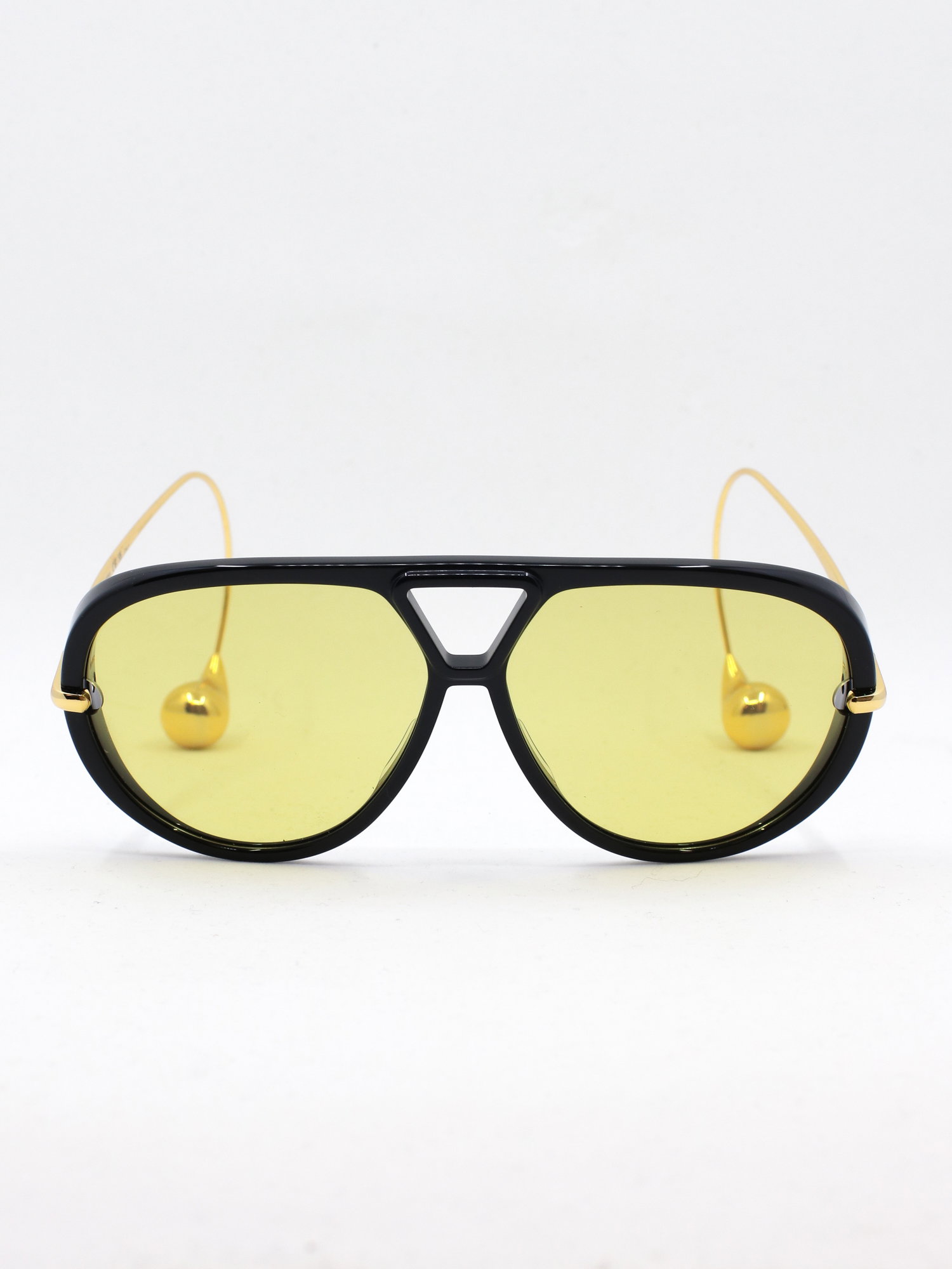 Pilotsolbrille i svart med gule glass og brillestenger med perleformede tupper