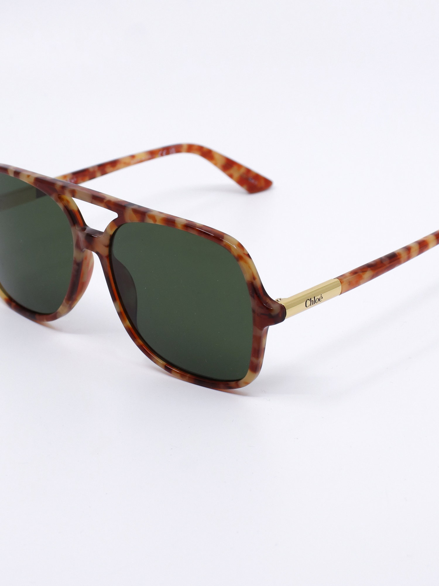 Pilotsolbrille med brunt, mønstret farge og grønne glass