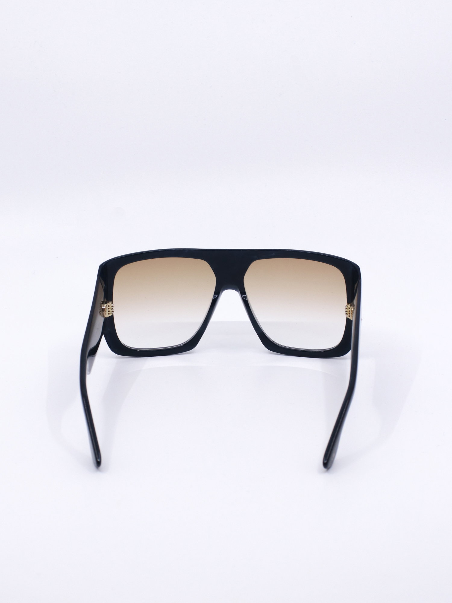 Solbrille med oversized fasong, kraftig svart ramme og brune, graderte glass
