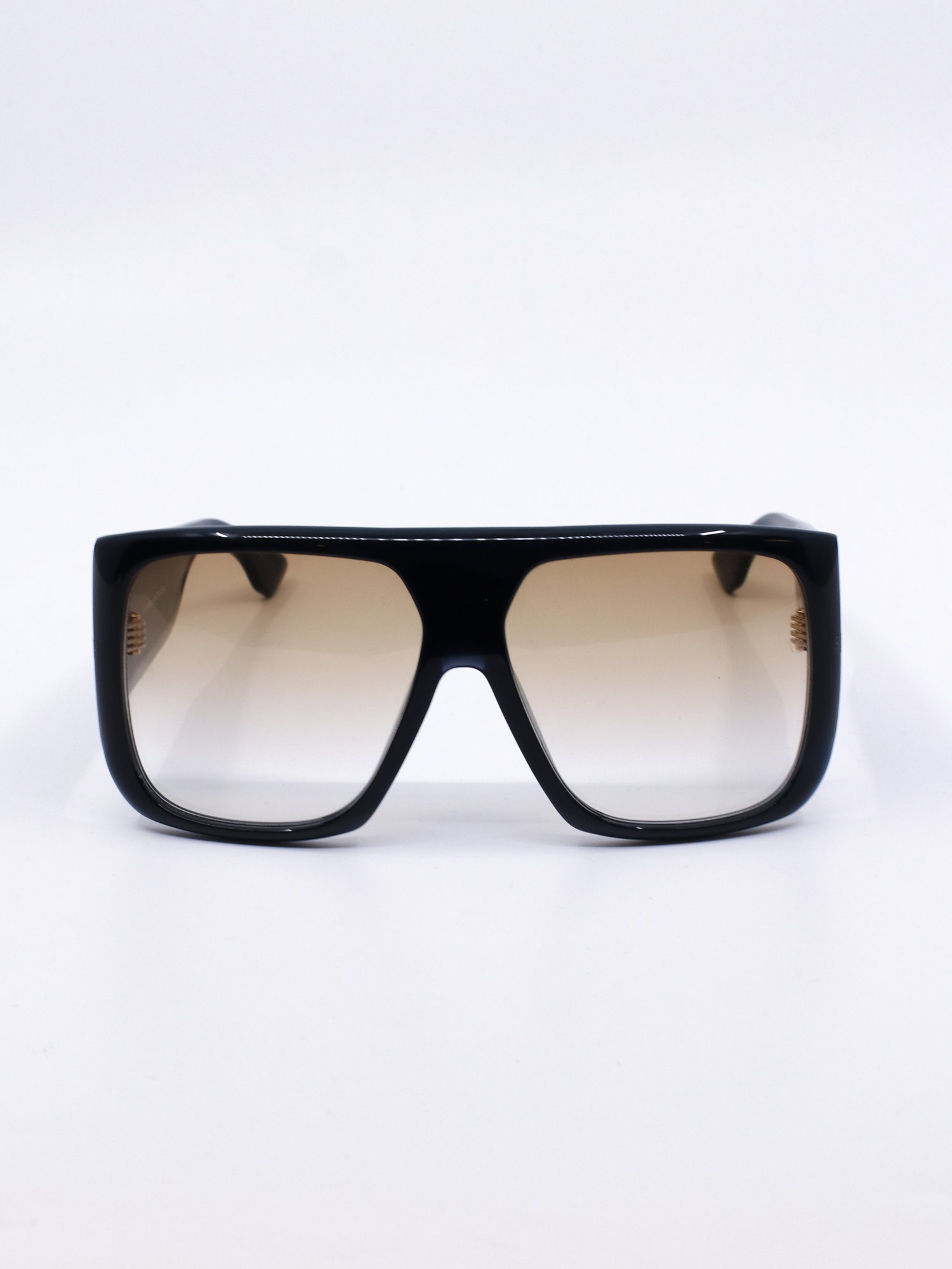 Solbrille med oversized fasong, kraftig svart ramme og brune, graderte glass