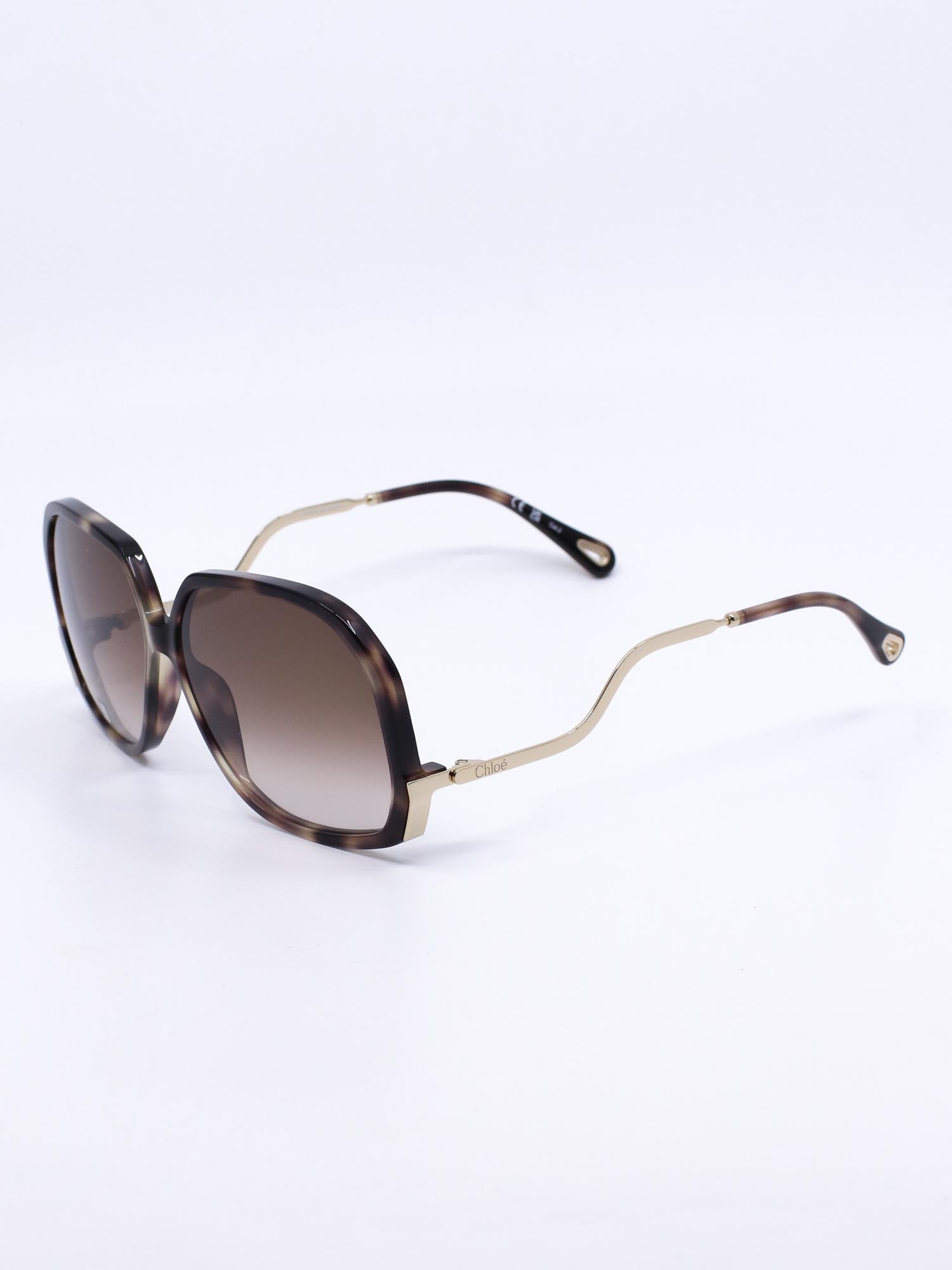 Oversized solbrille med organsik kvadratisk fasong og bølgede brillestenger