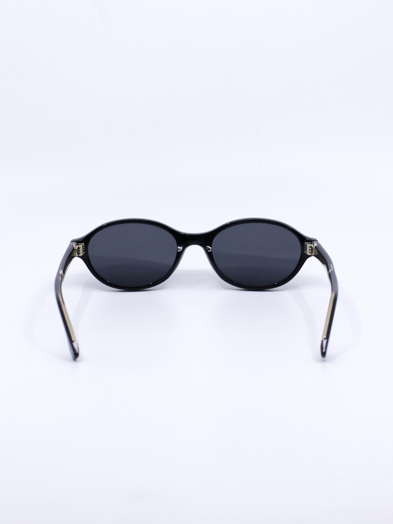 Oval solbrille med svart ramme og mørke glass