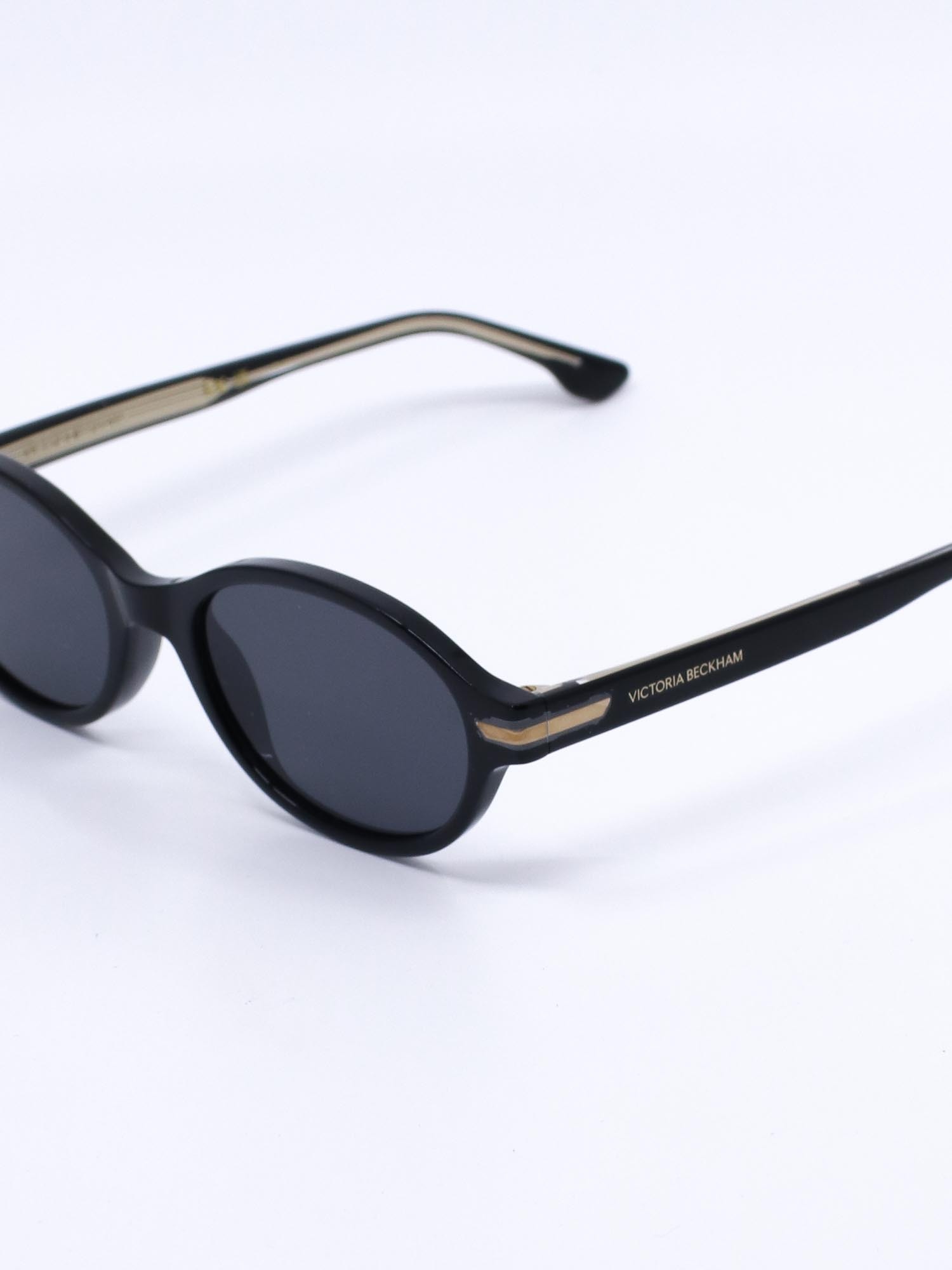 Oval solbrille med svart ramme og mørke glass