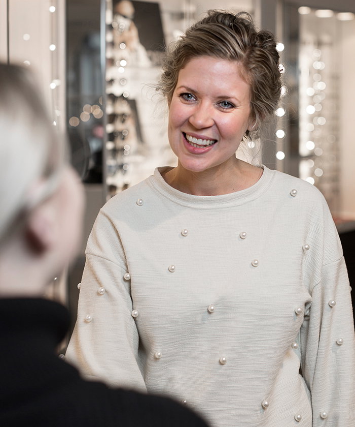 Bilde av butikksjef og optiker hos Krogh Optikk som hilser på kunde.