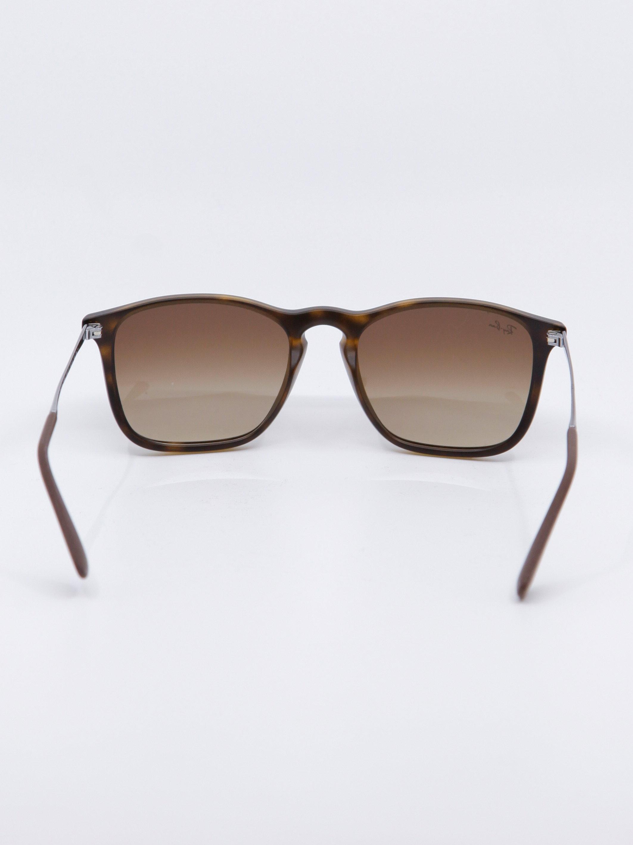 Brun og rund solbrille med brungraderte glass, bilde bak