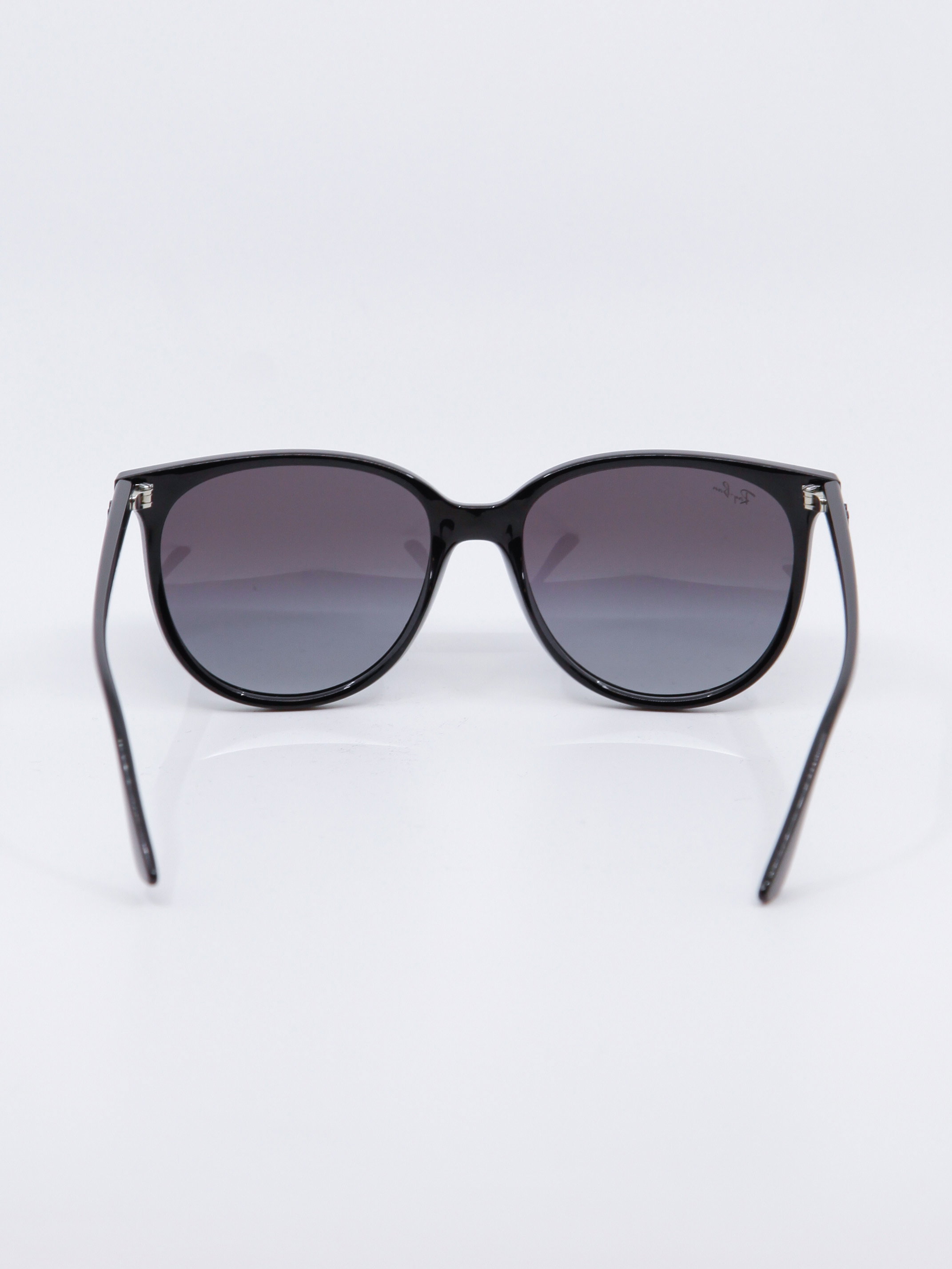 Sort og rund solbrille med svart ramme og gråblå glass, bilde bakfra