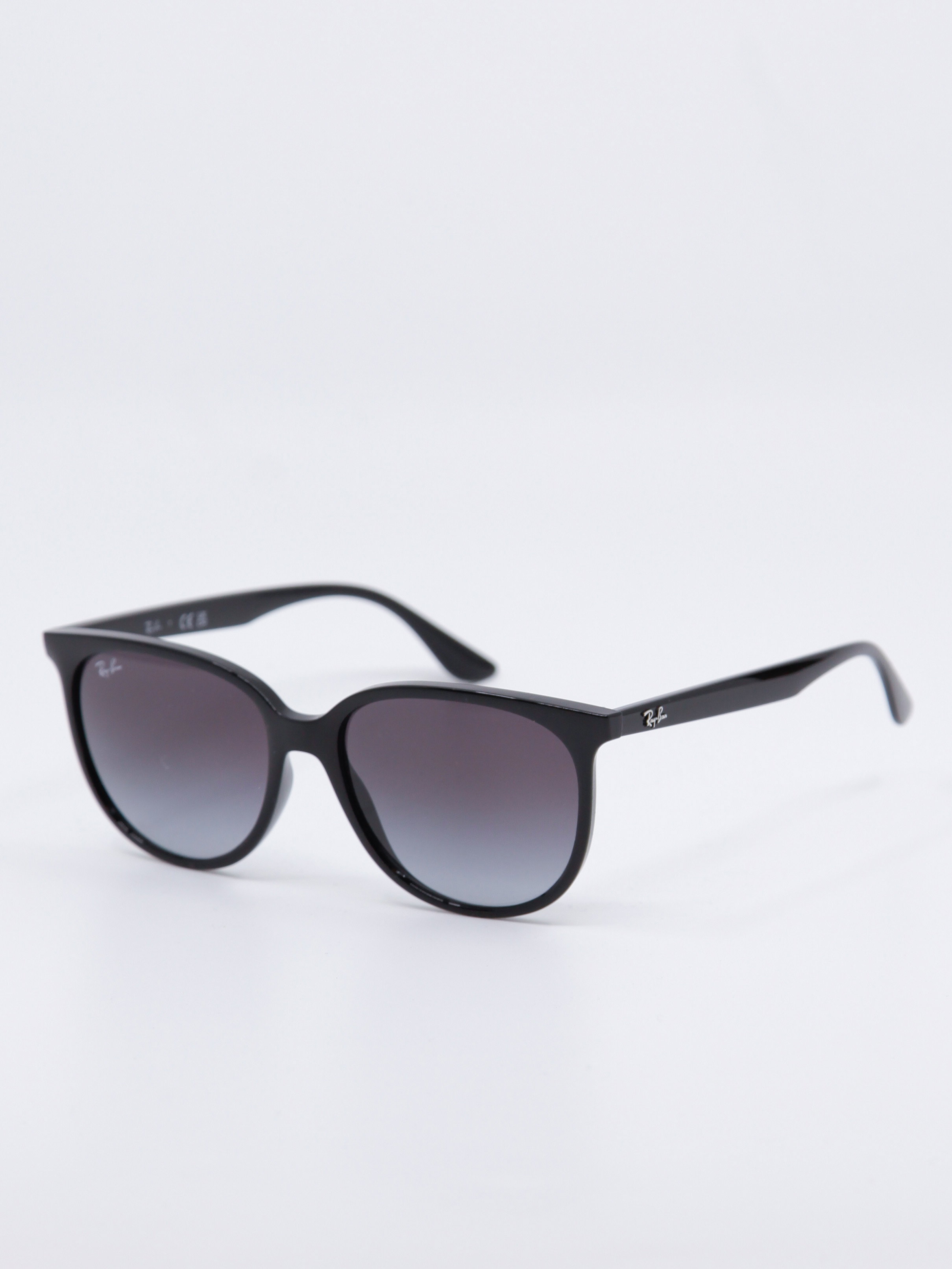 Sort og rund solbrille med svart ramme og gråblå glass, bilde fra siden